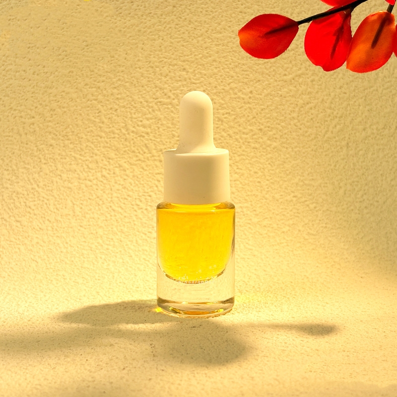 Małe szklane butelki na olejki eteryczne z metalowymi lub drewnianymi zakraplaczami